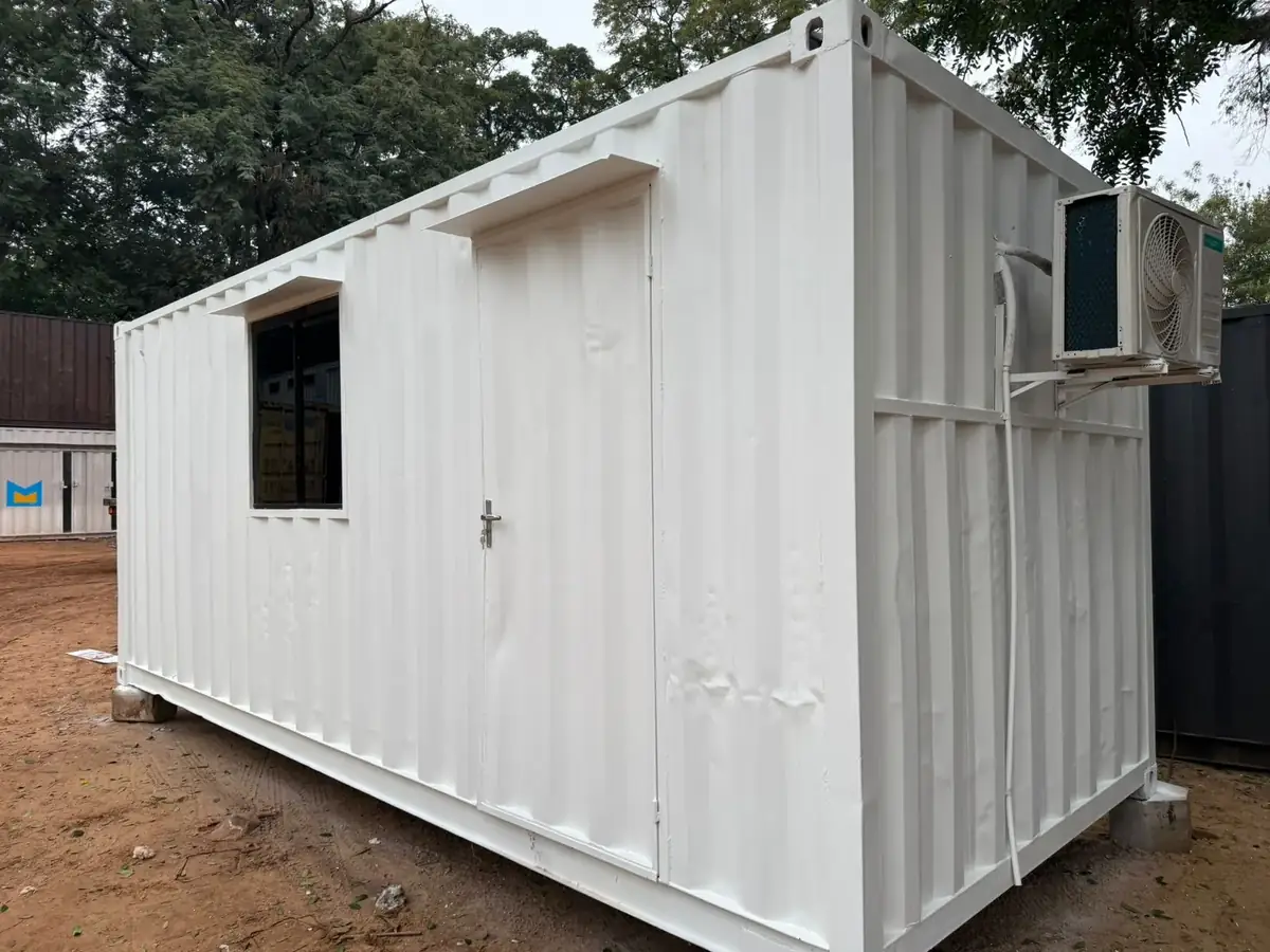 Contenedor oficina de 20 pies con ventana instalado sobre tierra roja